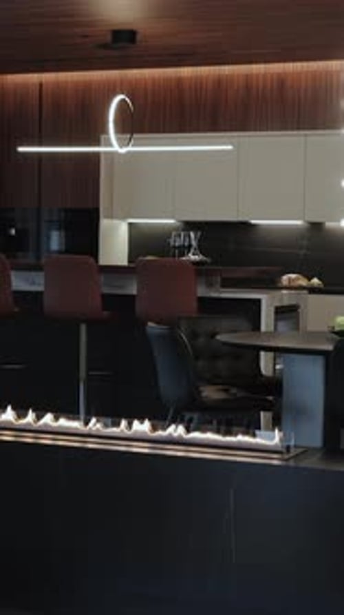 Contemporary Kitchen Interior with Elegant Lighting and a Variety of Bar Seating and a Gas Fireplace