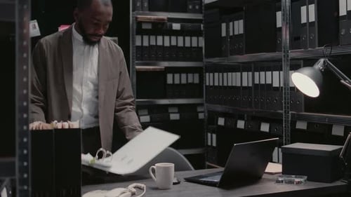 Detective Reviewing Documents in Dark Office