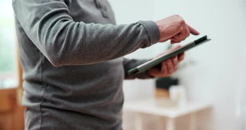 Adult Interacts With Tablet Device At Home