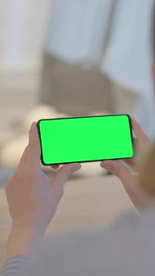 Young Woman Holding Phone with Chroma Key Screen, vertical video