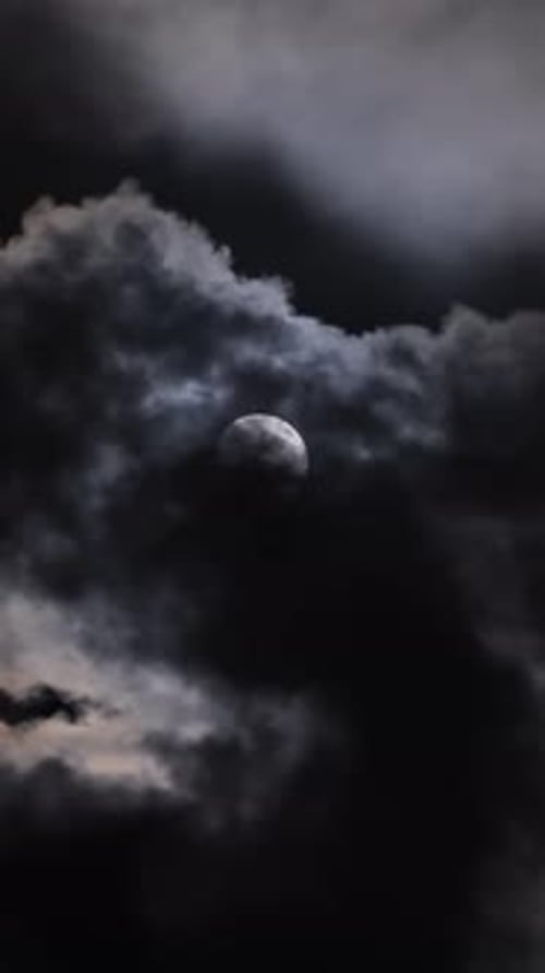 Full Moon Moving Between Clouds