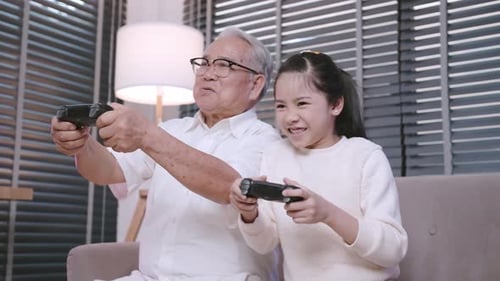 Senior and Child Playing Video Games Together Indoors