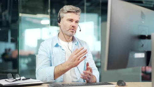 Man Using Headset Talking in Modern Office Setting