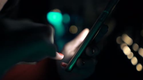 Female Hands Using Smartphone Sitting in Bar at Night 30s