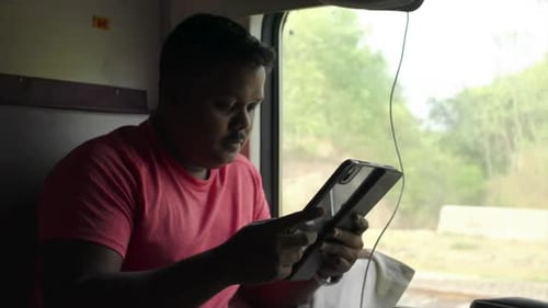 ein Pfarrer genießt mit seinem I-Pad die Zugfahrt