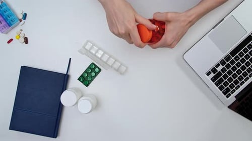 Organizing Daily Medications with Pill Organizer on Desk