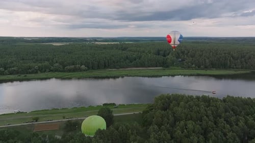 Hot Air Balloons Flying Over the Forest and Lakes at Dusk