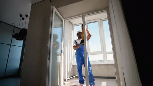 Technician Ensures Perfect Alignment While Installing Window