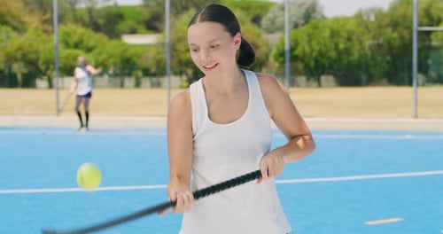 Active girl hockey player using motor skills while bouncing a tennis ball on her hockey stick