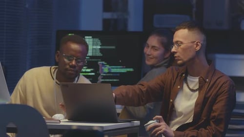 Diverse Team of Programmers Coding and Talking at Night Office