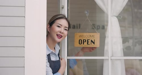 Cheerful Woman Opens Her Business for the Day