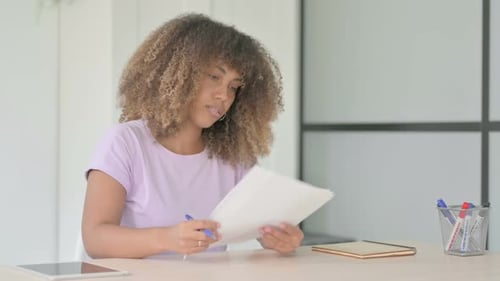 Woman Reviews Documents at Bright Desk