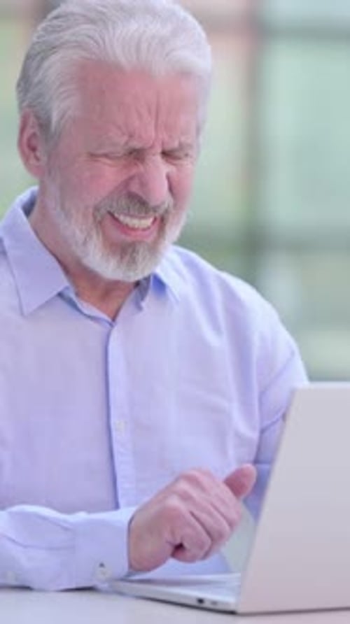 Senior Man Experiencing Neck Pain While Using Laptop