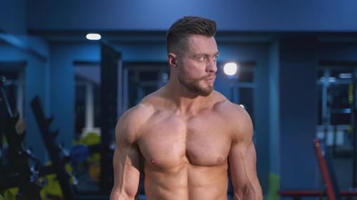 Shirtless Muscular Man in a Gym Looks Around
