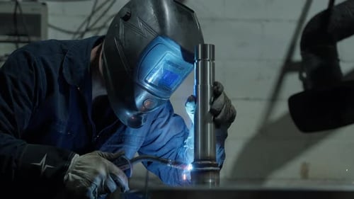 Metal Worker Welding Steel Component in Workshop