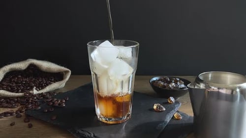 Pouring Refreshing Ice Coffee in a Glass
