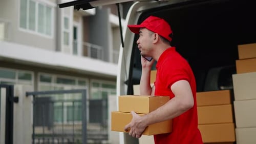 Delivery man, driver calling to customerr for sending parcel box package in the cargo truck at home