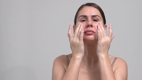 Middle Aged Woman Grey Background. Female 40 Year Lady Applying Moisturizing Cream Face. Facial Mass