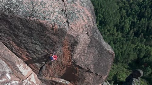 Climber Abseiling Down a Huge Cliff