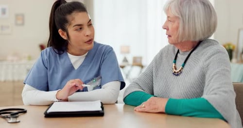 Nurse Talking with Senior Woman Patient Indoors