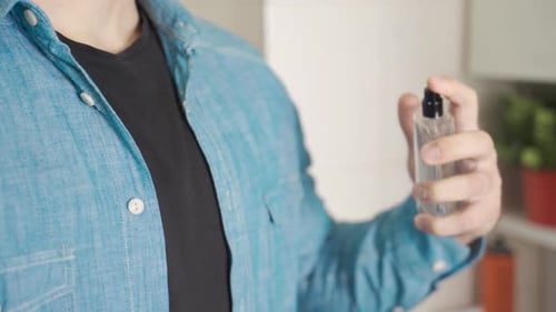 Close-up man squeezing perfume.