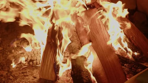 Slow motion close up of crackling campfire at night