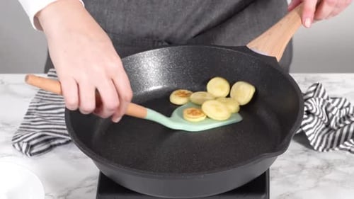 Schritt für Schritt Mini-Pfannkuchen-Müsli in einer antihaftbeschichteten Pfanne braten