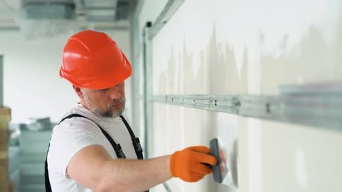 Construction Worker Plastering Wall Indoors