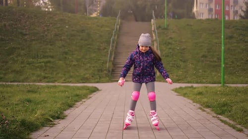 Eight Years Girl Roller Skating in Slow Motion Outdoors in City Park at Autumn Cloudy Day
