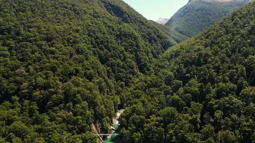 Aerial drone shot over Blue Pools river water flowing through green vegetation covered mountain rang