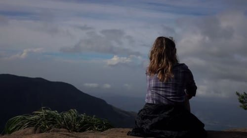 Mujer disfrutando de la vista a la montaña en un viaje de verano admirando la naturaleza y el paisaje