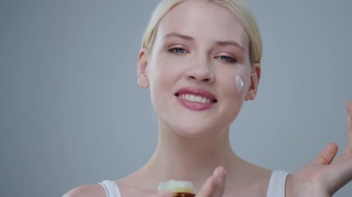 Woman Applying Moisturizing Cream for Skincare and Beauty