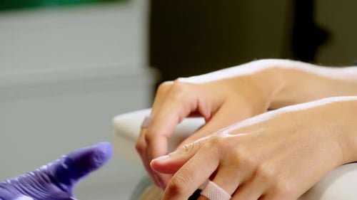 Hands of Master Cleanse Fingernails of Young Female Customer