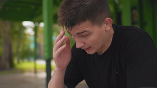 Reflective Individual Relaxing in Peaceful Garden Setting After Workout Contemplative Man Seated