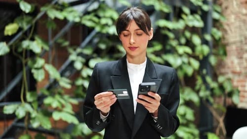 Happy Businesswoman Making Online Payment with Credit Card and Phone