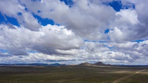 AERIAL Timelapse White Grey Clouds Passing Over Mojave Desert, In