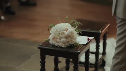 Elegant bridal bouquet sitting on stool indoors