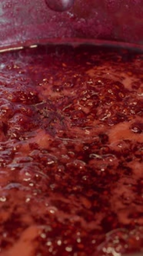 Simmering Red Raspberry Jam in Silver Pot