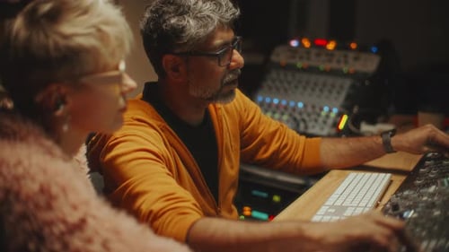 Female Singer and Sound Engineer Working on New Album in Recording Studio