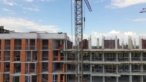 Tower Cranes and Workers at High Concrete Residential Building Under Construction