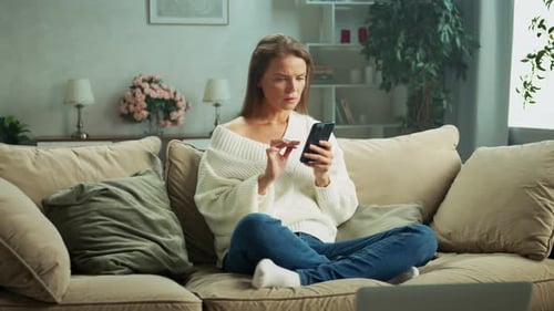 Woman Using Smartphone on Couch at Home