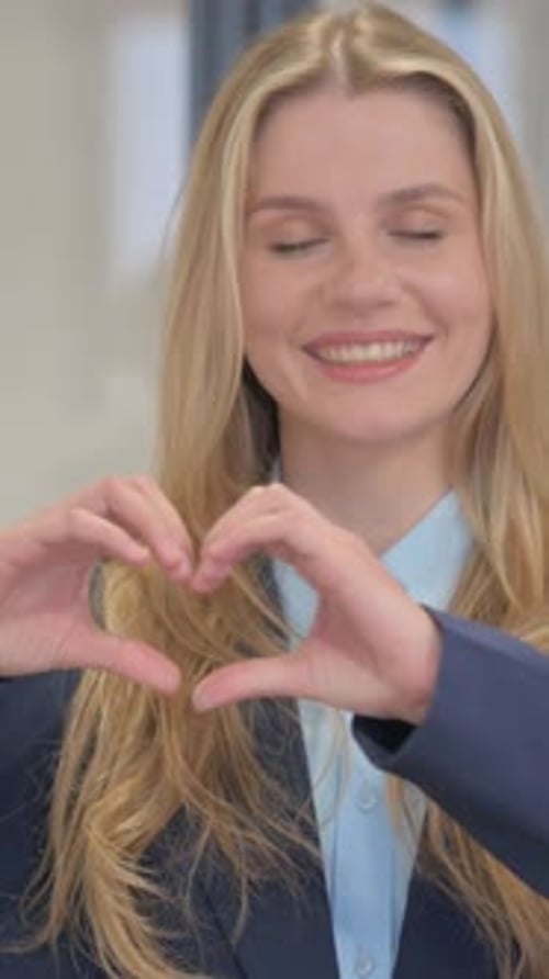 Smiling Woman Making Heart Shape with Hands