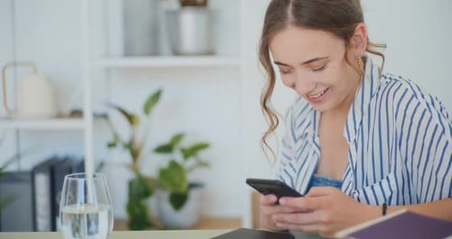 Woman Using Smartphone Indoors at Desk