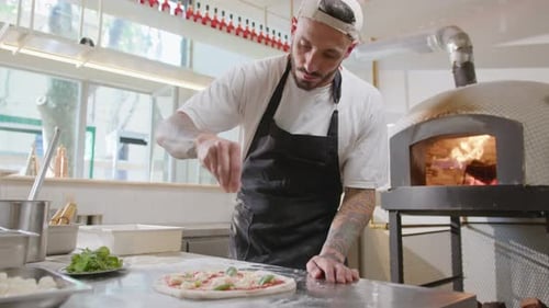 Chef Preparing Pizza in Bright Restaurant Kitchen