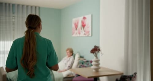 Woman Visiting Senior Patient in Hospital Room