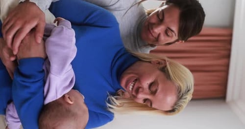 Women gay couple having fun with their baby son at home - Family, lgbt and love concept