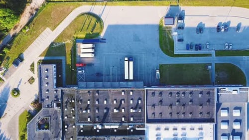 Aerial shot of industrial warehouse. Loading hub and many trucks with cargo trailers. Aerial view of