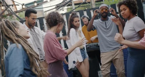 Diverse Group of Young People Dancing Relaxing Listening to DJ Music Having Fun at Outdoor Cafe in