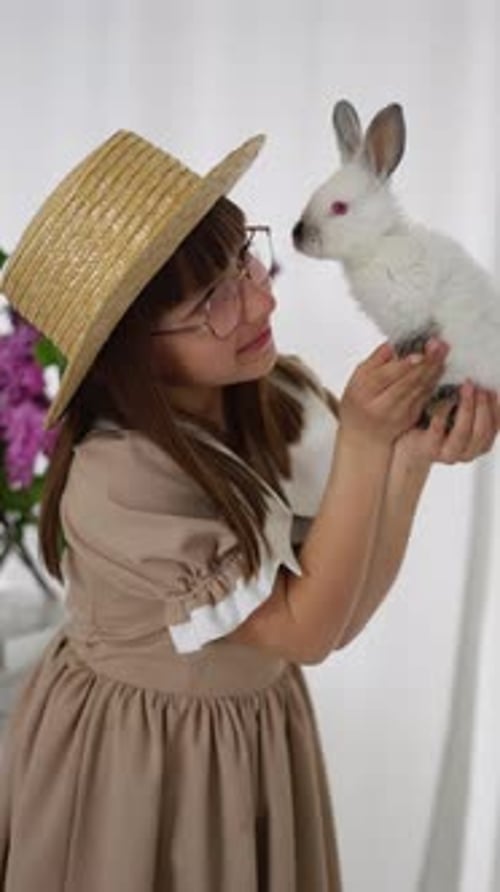 Girl Holds White Rabbit Lovingly Indoors