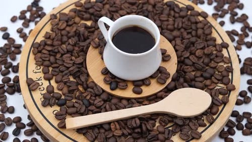 Coffee Cup Surrounded by Coffee Beans and Spoon